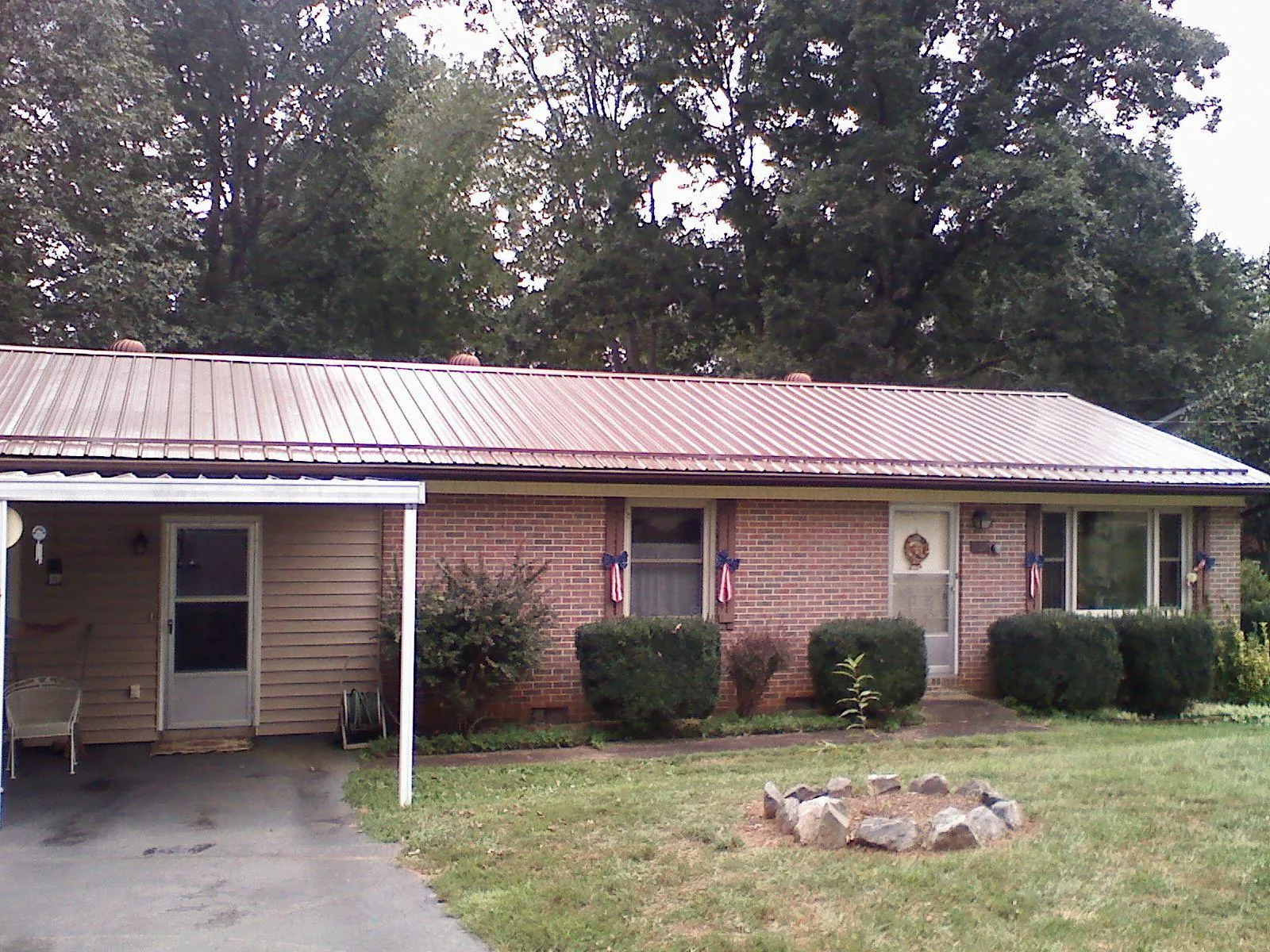 Bronze metal roof and carport on a brick ranch home — Roof Repair work by our crew in Hobe Sound