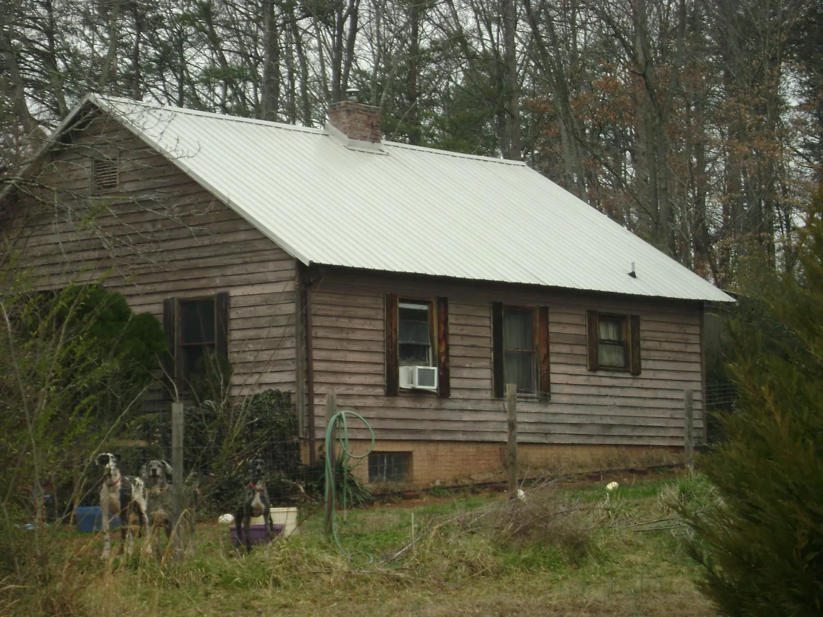 White metal roof on an old wood sided farmhouse, from a Metal Roof Installation job in Hobe Sound